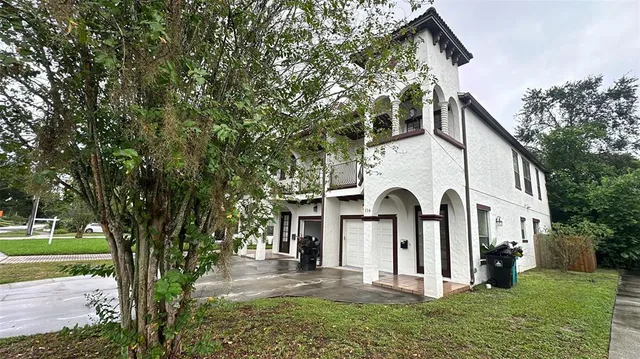 a view of a white house with a big yard and large tree