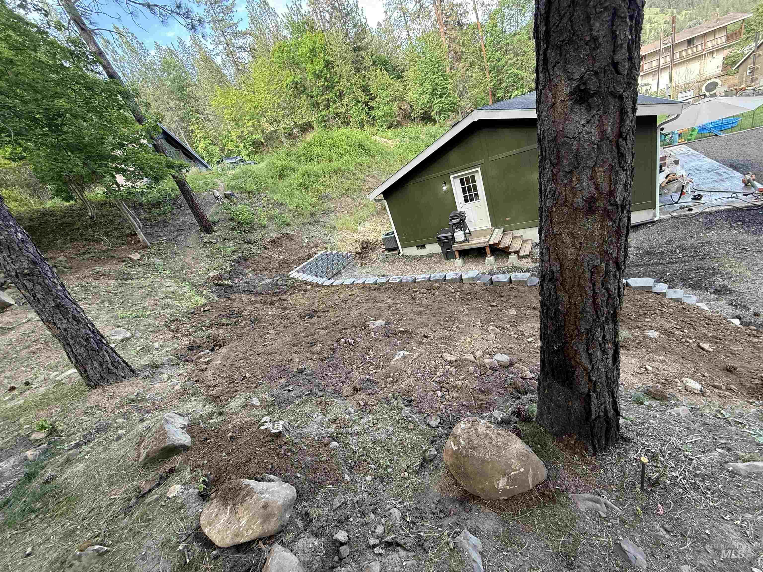 174 Konkolville Road Orofino, ID 83544 - Photo 31 of 43 Exterior building with green siding and a white door, featuring wood steps and a small landing