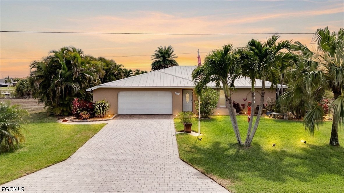 2912 Southwest 1st Terrace Cape Coral, FL 33991 - Photo 1 of 31 a front view of a house with a yard garage and a fountain