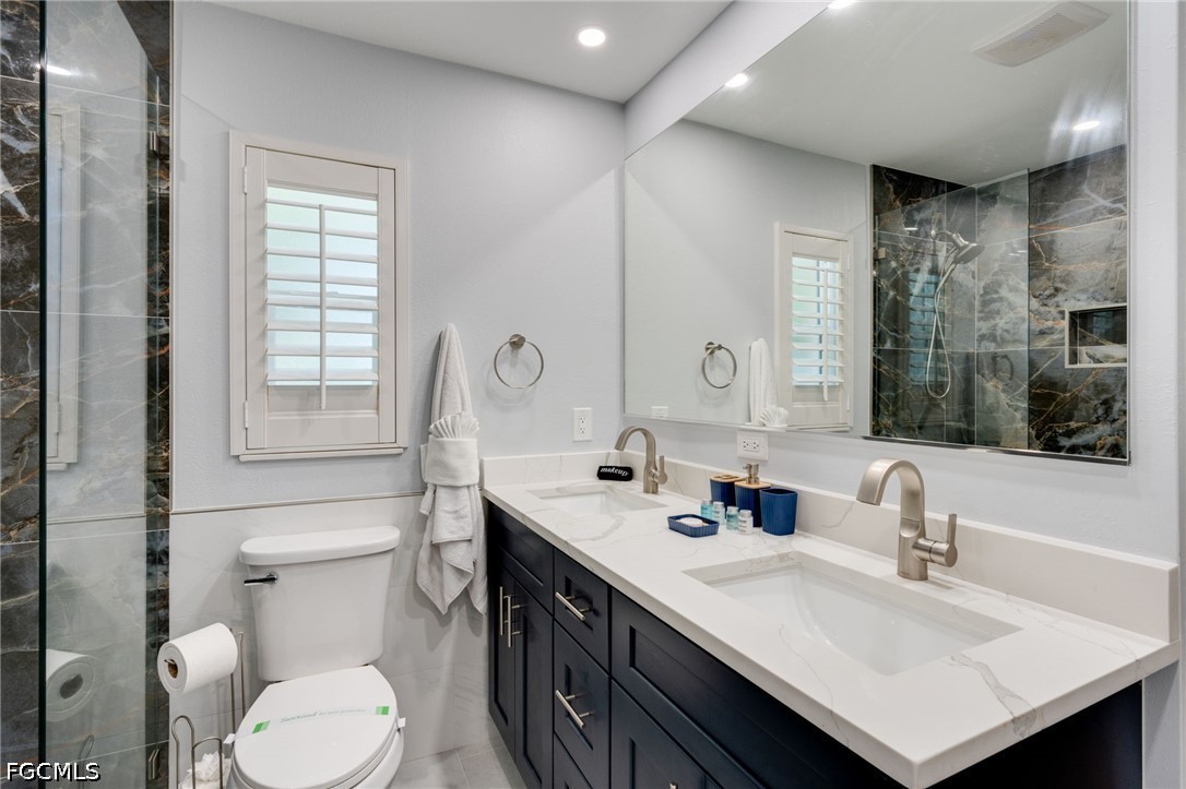 2912 Southwest 1st Terrace Cape Coral, FL 33991 - Photo 14 of 31 a bathroom with a sink vanity mirror and toilet