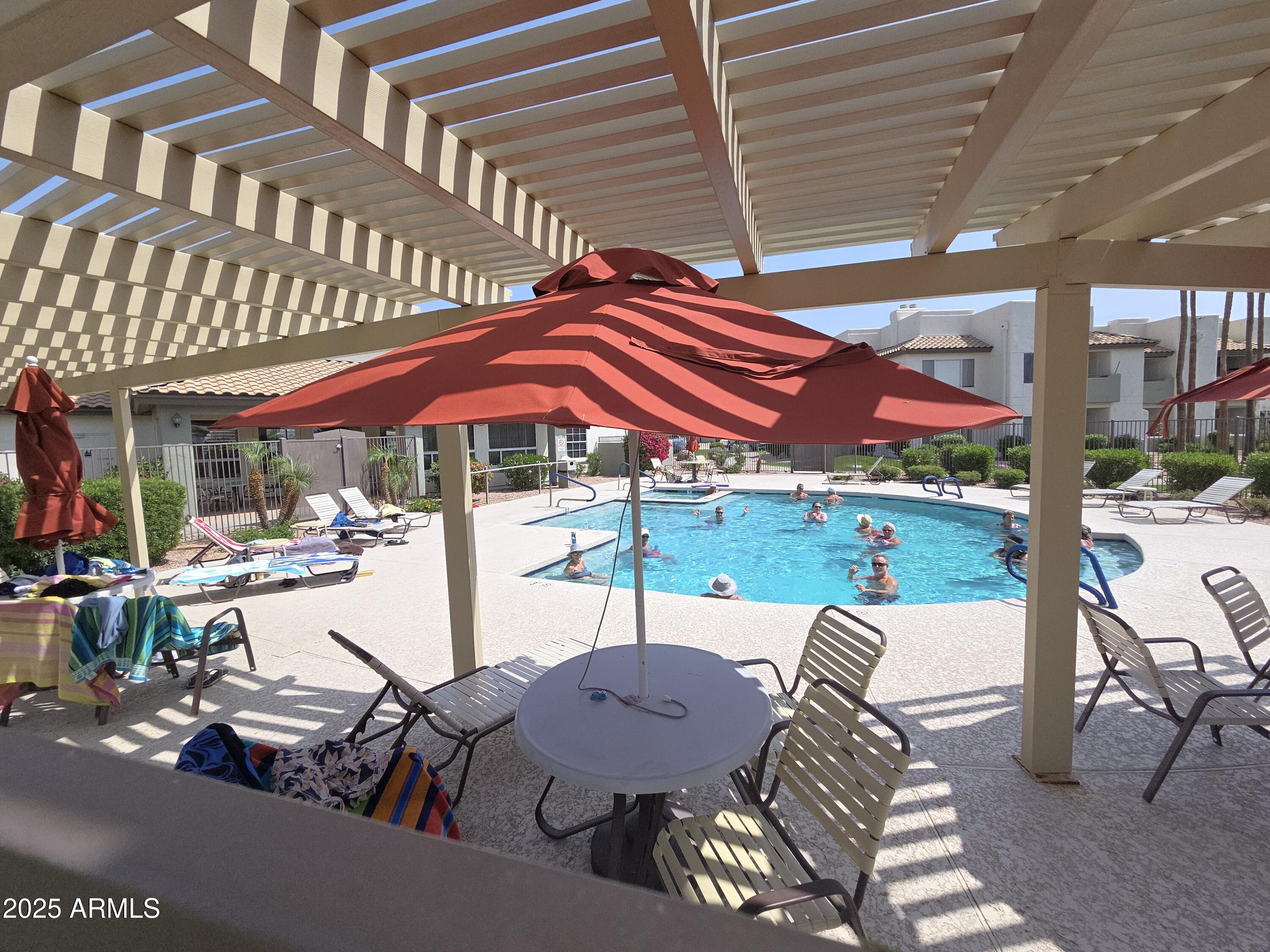 1825 West Ray Road, Unit 2031 Chandler, AZ 85224 - Photo 21 of 21 a view of a patio with a table and chairs under an umbrella