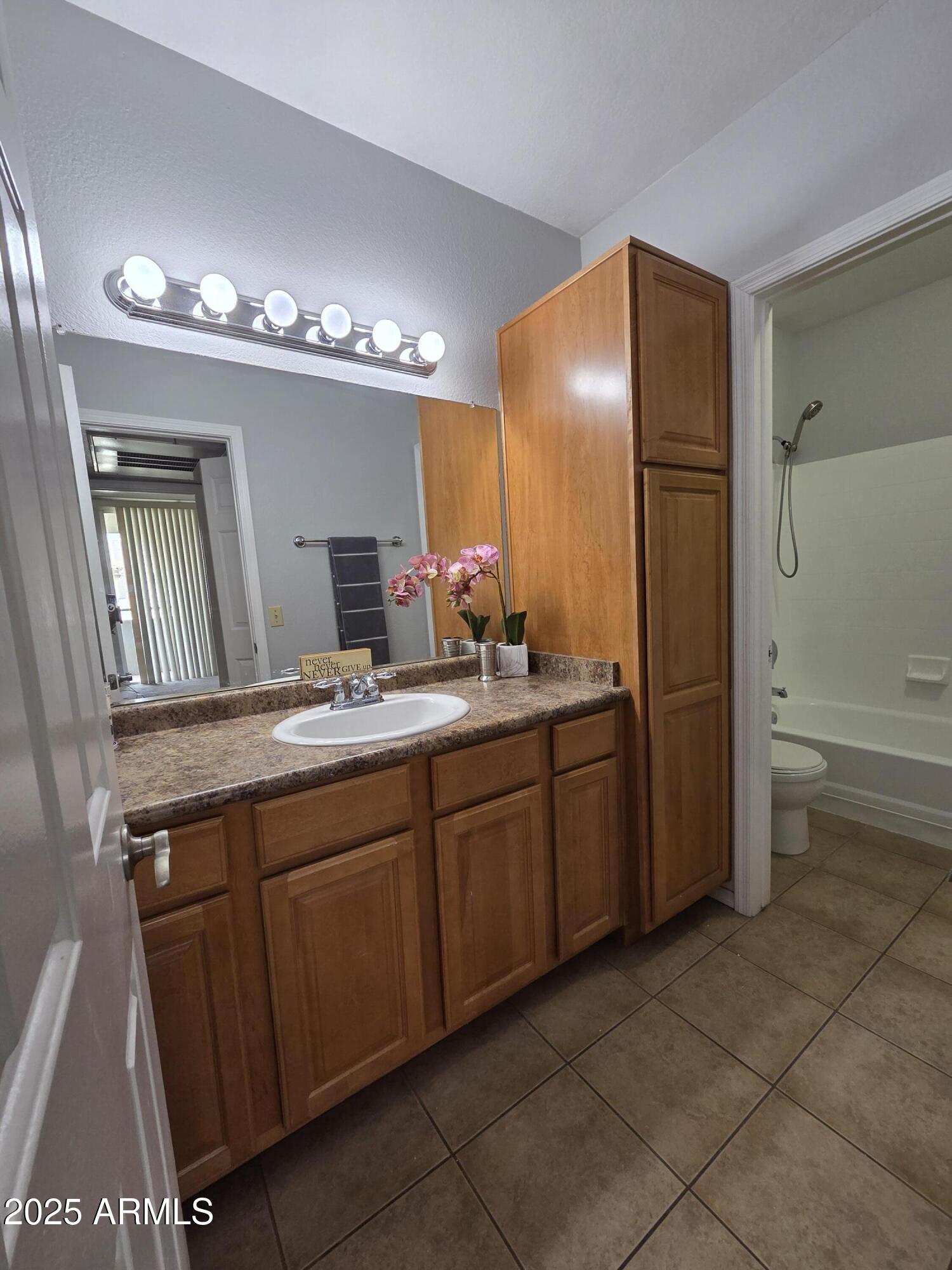 1825 West Ray Road, Unit 2031 Chandler, AZ 85224 - Photo 9 of 21 a spacious bathroom with a granite countertop sink a toilet a mirror and a bathtub