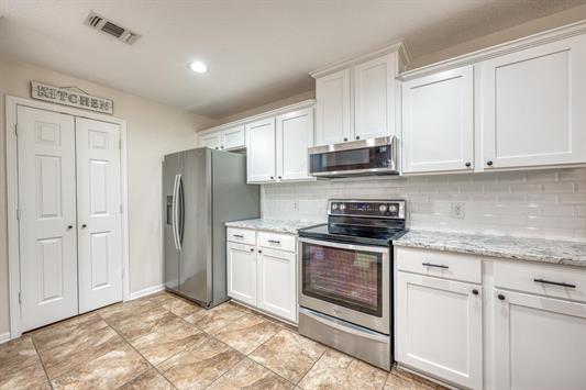 395 Lehne Loop Buchanan Dam, TX 78609 - Photo 13 of 27 a kitchen with stainless steel appliances granite countertop a stove a refrigerator and a refrigerator