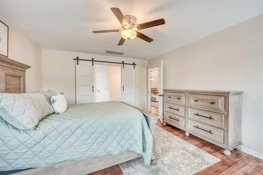 a bedroom with a bed a chandelier and a dresser