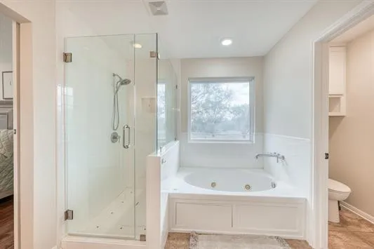 a spacious bedroom with a bed and a dresser