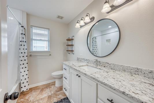 395 Lehne Loop Buchanan Dam, TX 78609 - Photo 22 of 27 a bathroom with a granite countertop sink mirror vanity and toilet