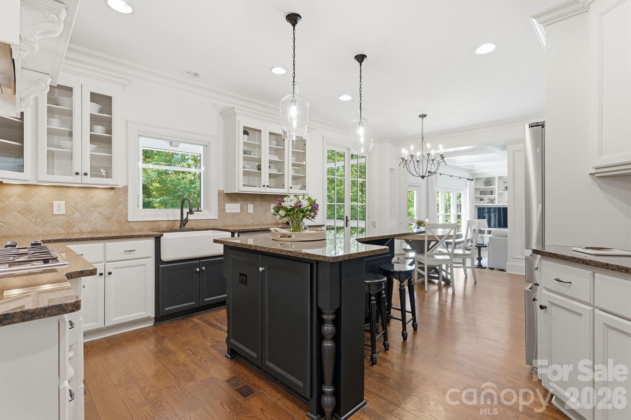 235 Grey Road Davidson, NC 28036 - Photo 6 of 42 a kitchen with stainless steel appliances granite countertop a stove a sink dishwasher and a wooden cabinets with wooden floor