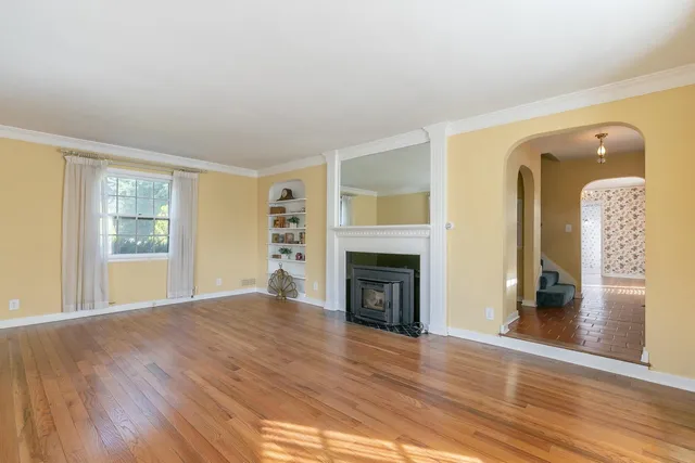 wooden floor fireplace and windows in an empty room