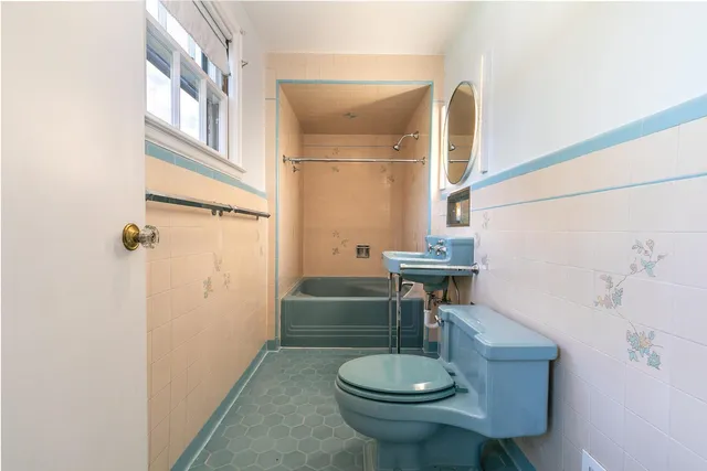 a bathroom with a toilet and a mirror