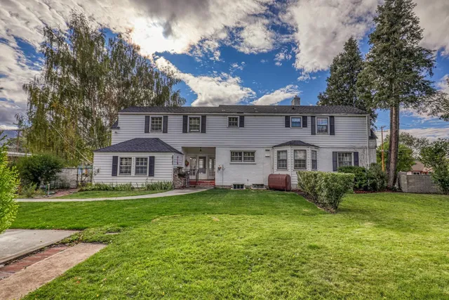 a view of a house with a big yard and potted plants