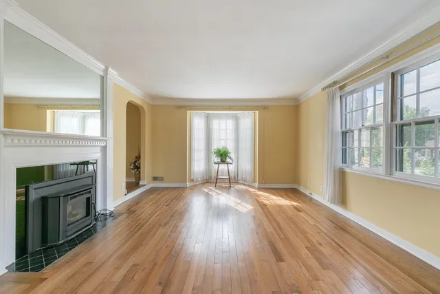 a view of empty room with wooden floor and fireplace