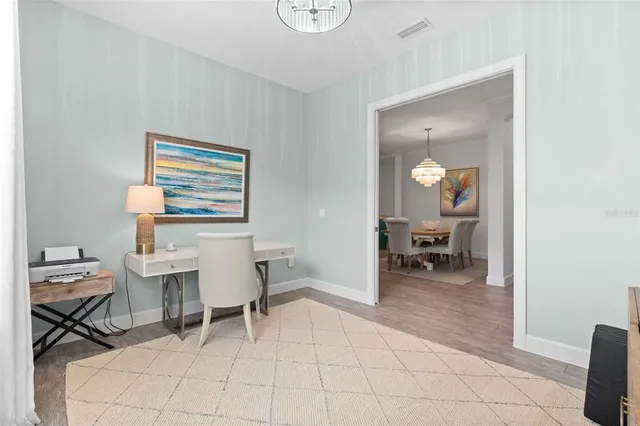 a kitchen with stainless steel appliances kitchen island granite countertop a dining table chairs refrigerator and cabinets