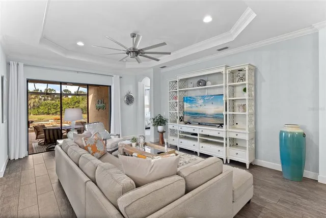 a kitchen with a stove a sink a kitchen island with white cabinets and wooden floor