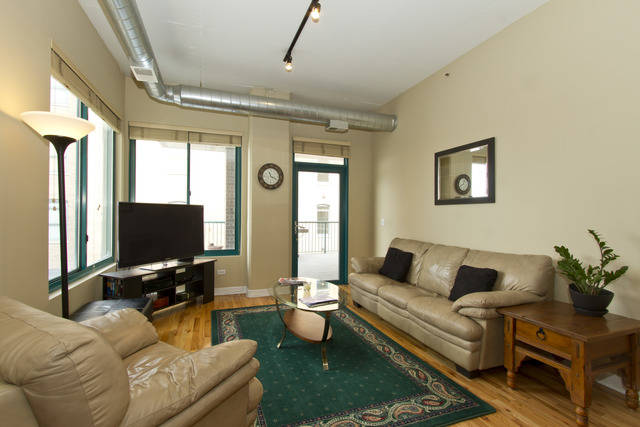 910 West Madison Street, Unit 609 Chicago, IL 60607 - Photo 4 of 12 a living room with furniture and a flat screen tv