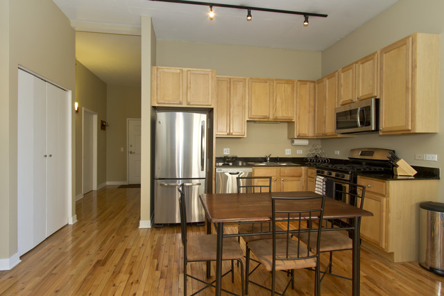 910 West Madison Street, Unit 609 Chicago, IL 60607 - Photo 5 of 12 a kitchen with stainless steel appliances granite countertop a refrigerator a stove a sink dishwasher and white cabinets with wooden floor