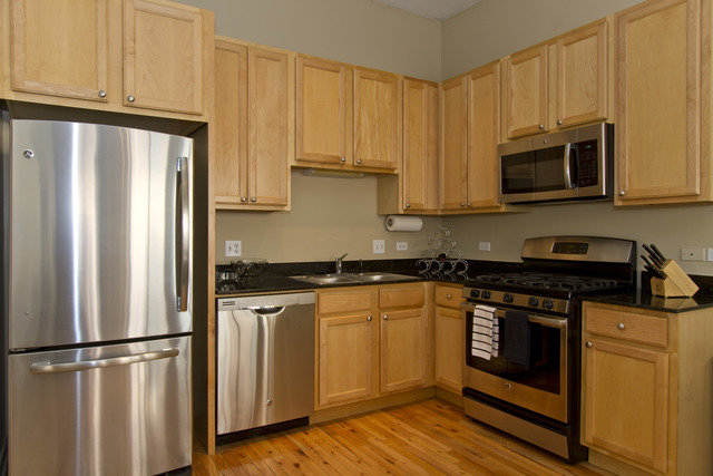 910 West Madison Street, Unit 609 Chicago, IL 60607 - Photo 6 of 12 a kitchen with stainless steel appliances granite countertop a refrigerator stove a sink and dishwasher with wooden floor