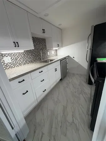 a kitchen with white cabinets and white appliances