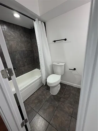 a bathroom with a toilet and a shower