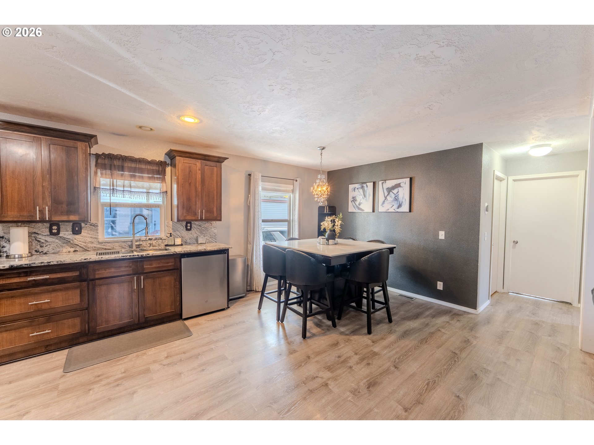 4364 Bren Loop Northeast, Unit 95 Salem, OR 97305 - Photo 13 of 34 a kitchen with kitchen island granite countertop a sink cabinets and wooden floor