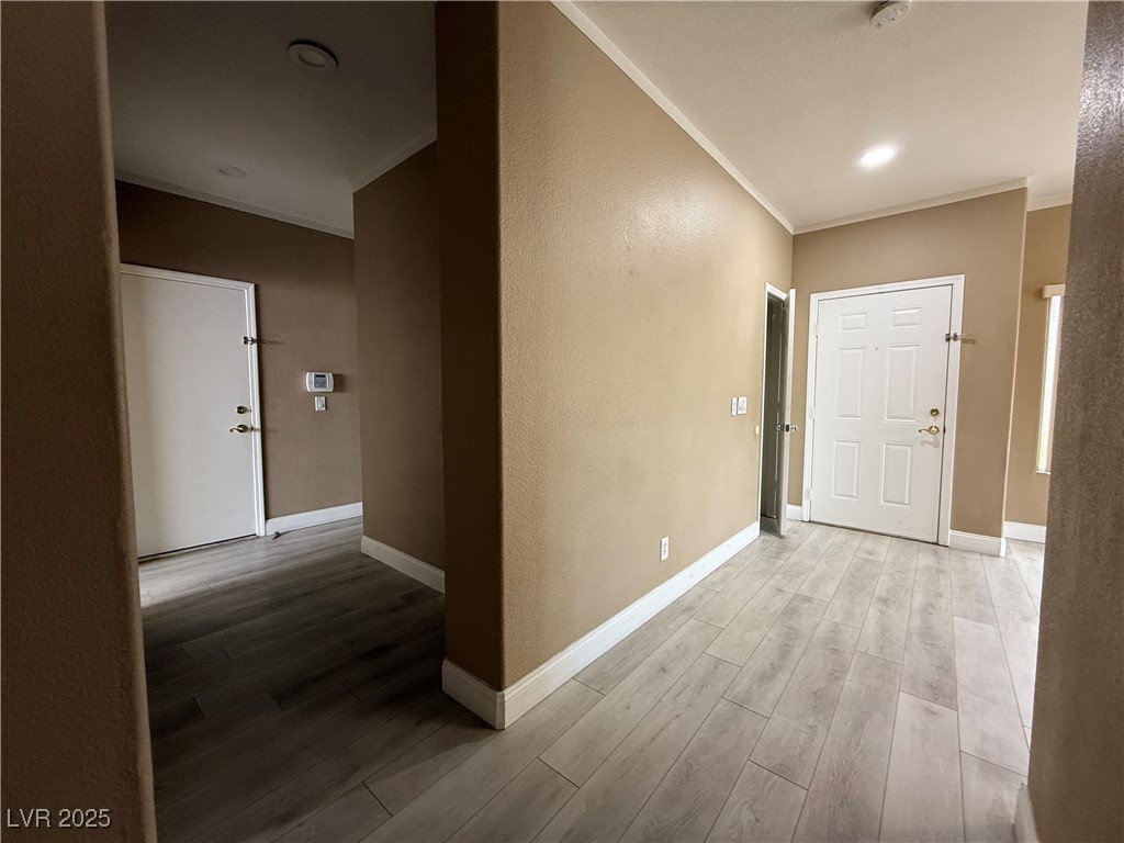 7062 Russell Ranch Avenue Las Vegas, NV 89113 - Photo 20 of 32 Hall featuring baseboards, light wood-style floors, and crown molding