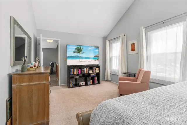 a bedroom with a bed and a flat tv screen next to a window