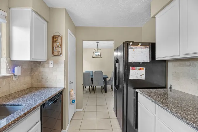 a open kitchen with granite countertop a sink and a stove top oven