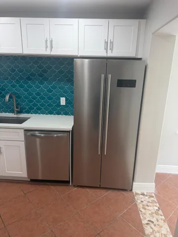 a view of a kitchen with refrigerator and cabinet