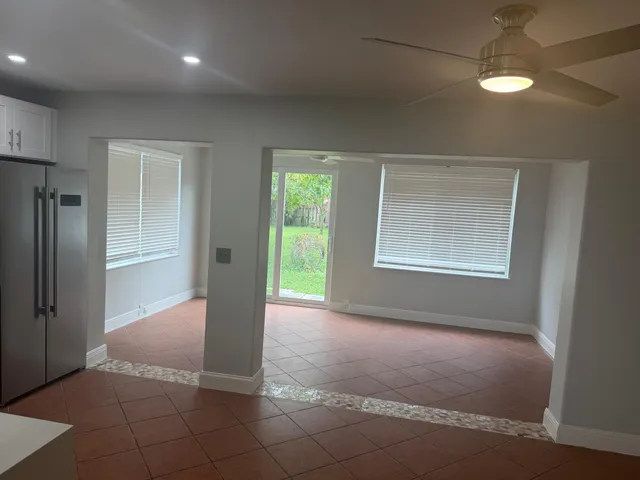 a kitchen with granite countertop a stove a sink and a refrigerator