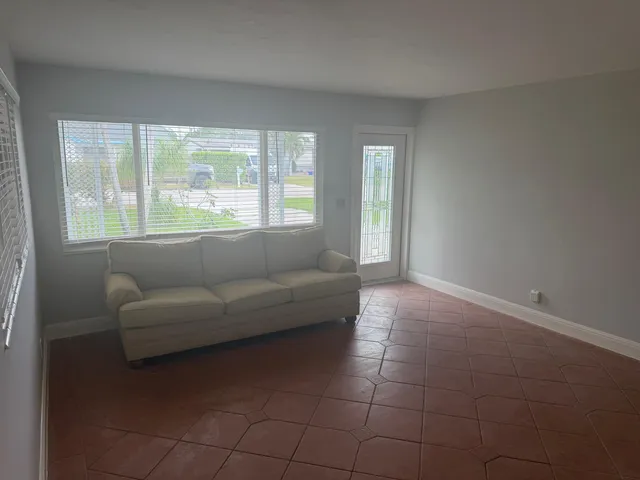 a living room with a large window couches and table chair