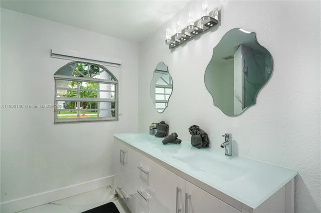 a bathroom with a sink mirror and window