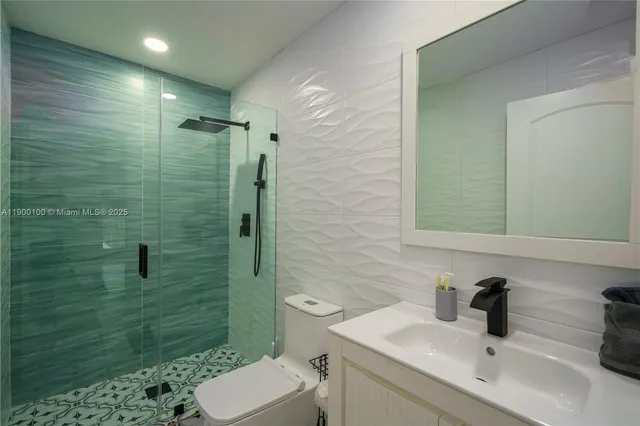 a bathroom with a sink a toilet and shower