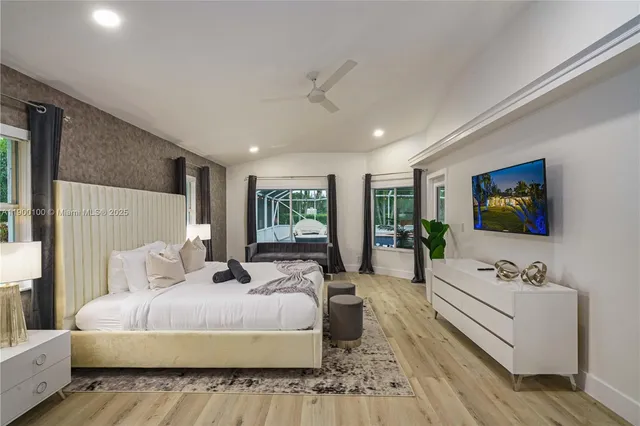 a bedroom with a large bed and a flat screen tv