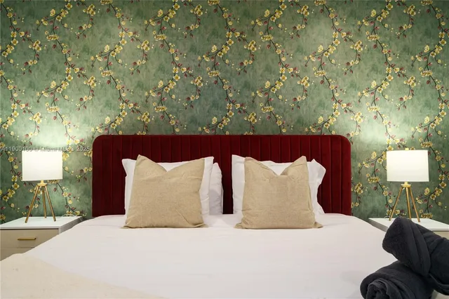 a large bed sitting in a bedroom next to a lamp