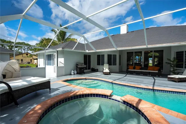 a view of a patio with table and chairs under an umbrella