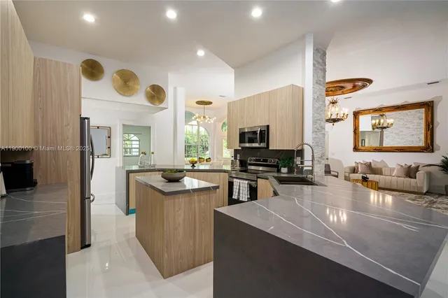 a kitchen with stainless steel appliances granite countertop a sink a stove counter space and cabinets