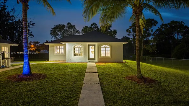 an aerial view of a house with swimming pool and large trees