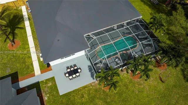 a view of a swimming pool with a patio and garden