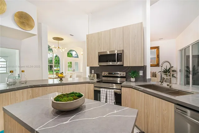 a kitchen with a sink and a stove top oven with wooden floor