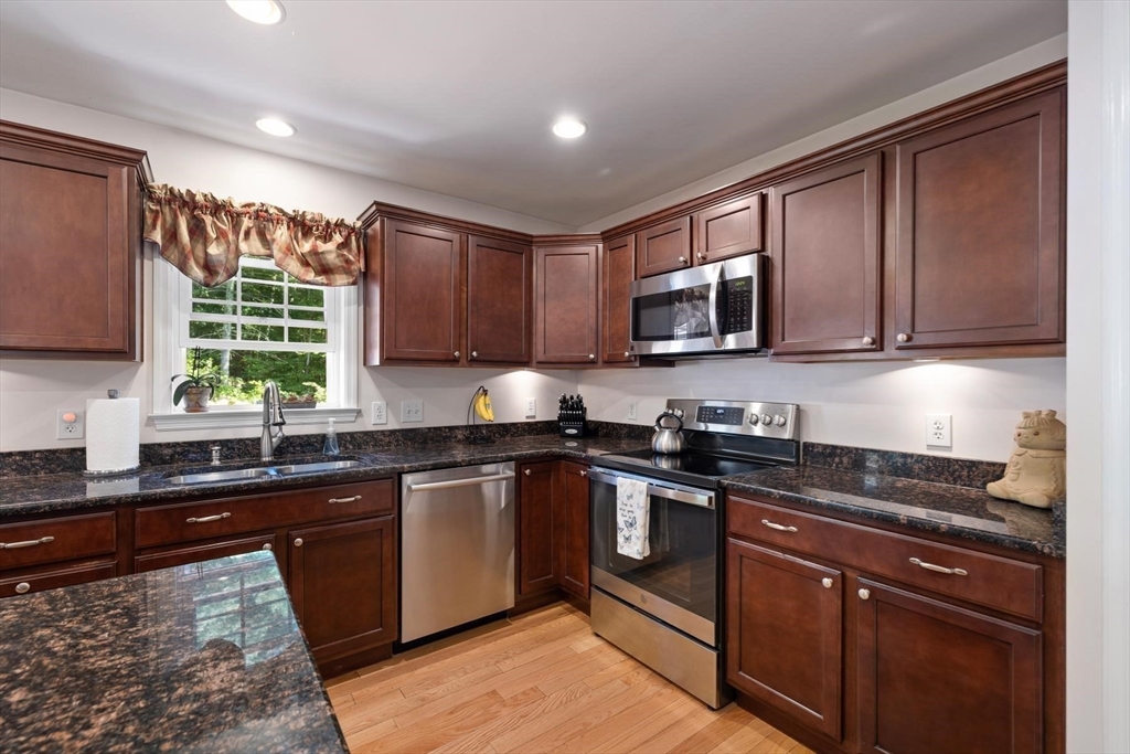 297 Manchaug Road Sutton, MA 01590 - Photo 11 of 40 a kitchen with stainless steel appliances granite countertop wooden cabinets a stove top oven a sink and dishwasher