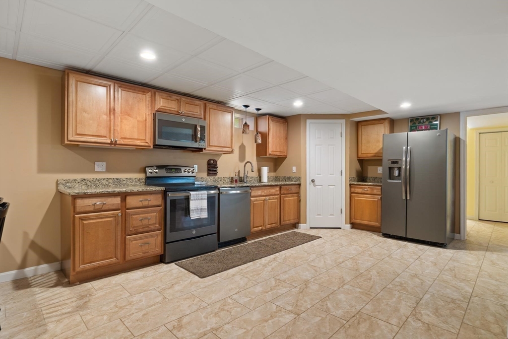 297 Manchaug Road Sutton, MA 01590 - Photo 20 of 40 a kitchen with granite countertop a refrigerator and a stove top oven