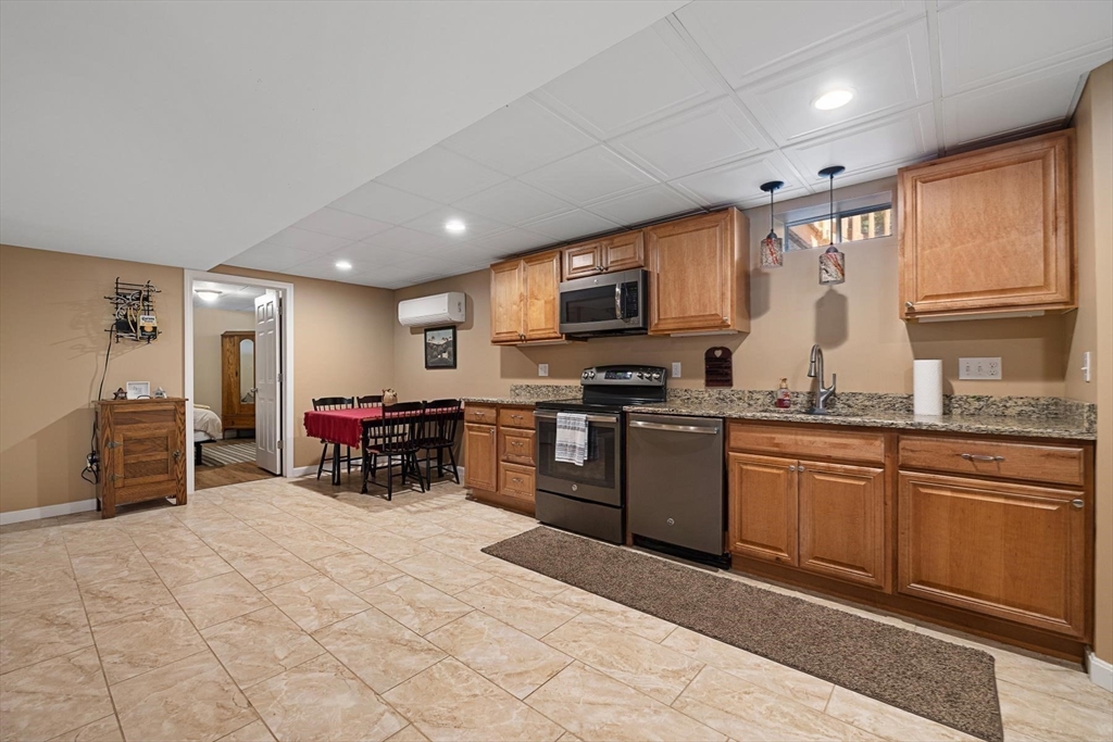 297 Manchaug Road Sutton, MA 01590 - Photo 22 of 40 a kitchen with stainless steel appliances granite countertop a stove sink and cabinets