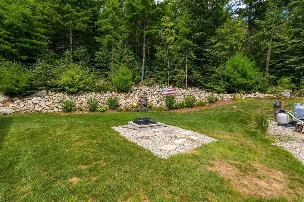 297 Manchaug Road Sutton, MA 01590 - Photo 28 of 40 a view of a garden with lawn chairs and plants