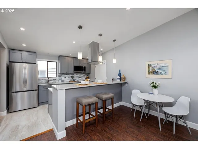 a kitchen with a dining table chairs refrigerator and microwave