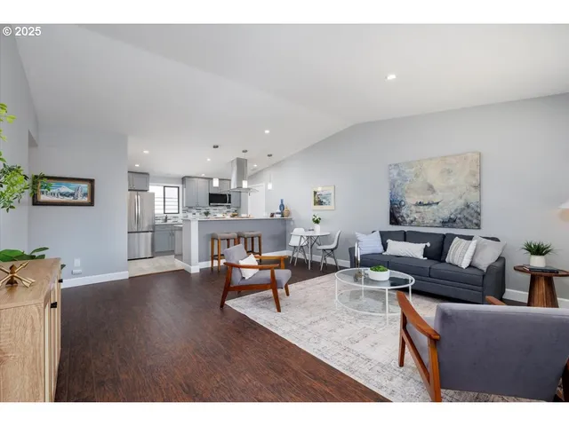 a living room with lots of furniture and kitchen view