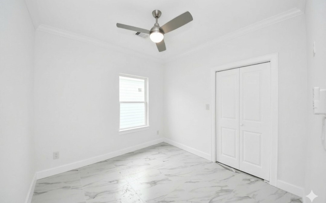 8312 Comal Street Houston, TX 77051 - Photo 11 of 17 an empty room with a window and a ceiling fan