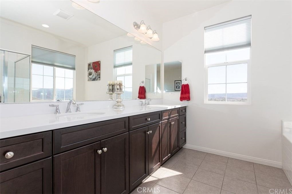 24125 Montecito Drive Wildomar, CA 92595 - Photo 11 of 25 a bathroom with a sink vanity and mirror