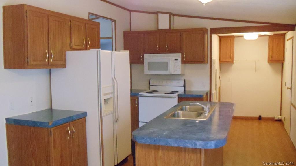 1766 North Ingleside Farm Road Iron Station, NC 28080 - Photo 17 of 23 a kitchen with a refrigerator a stove and a wooden cabinets