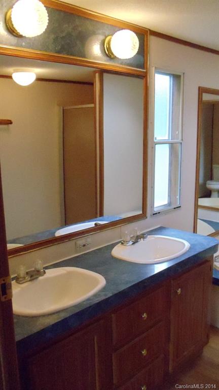 1766 North Ingleside Farm Road Iron Station, NC 28080 - Photo 10 of 23 a bathroom with a granite countertop sink and a mirror