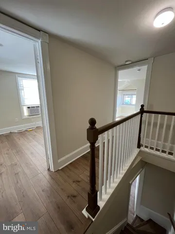 a view of a hallway with wooden floor and staircase
