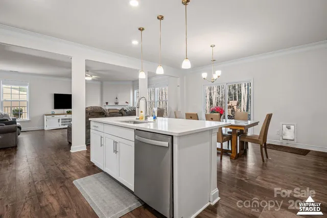 a kitchen with a dining table chairs sink and cabinets